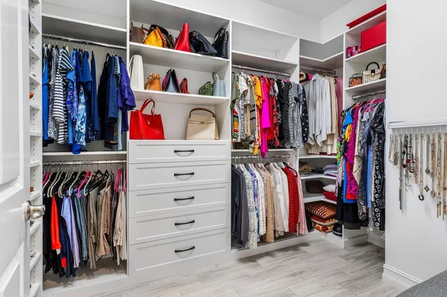 a view of walk in closet with clothes