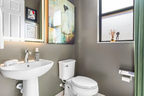 a bathroom with a toilet a sink and mirror