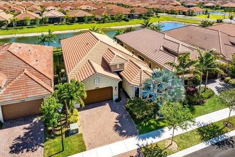 an aerial view of a house with a garden and lake view