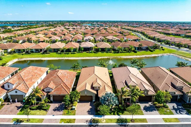 an aerial view of residential houses with yard and lake view