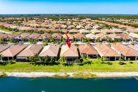 an aerial view of residential houses with yard and lake view