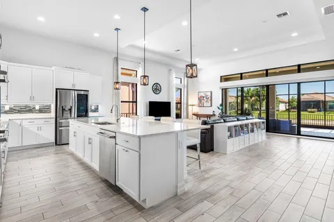 a large white kitchen with a large window and stainless steel appliances