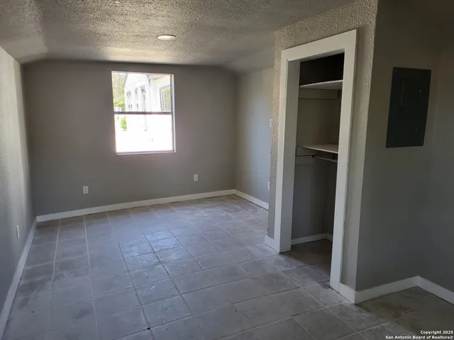 an empty room with windows and closet