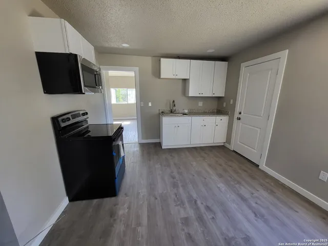 a kitchen with a sink and wooden floor