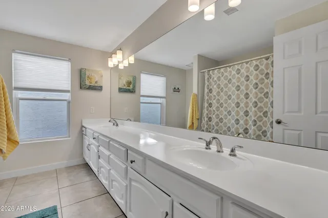 a spacious bedroom with a bed and a flat screen tv