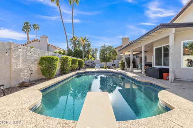 a view of a patio with a table and chairs under an umbrella