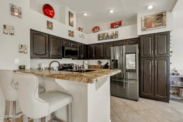 a kitchen with stainless steel appliances granite countertop a refrigerator and a stove top oven