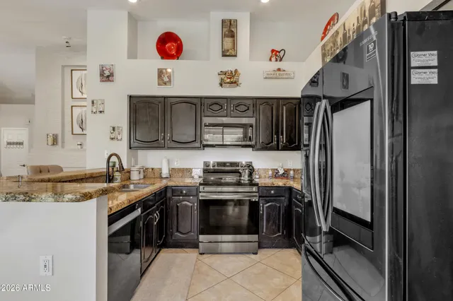 a kitchen with stainless steel appliances granite countertop a stove microwave and sink