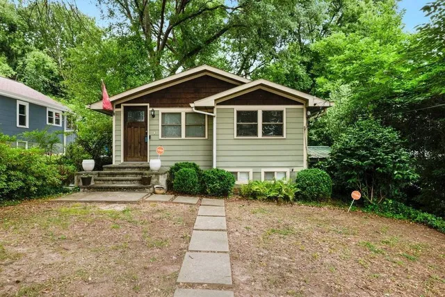 a front view of a house with a yard and trees