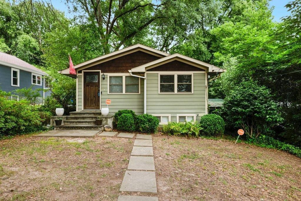 a front view of a house with a yard and trees