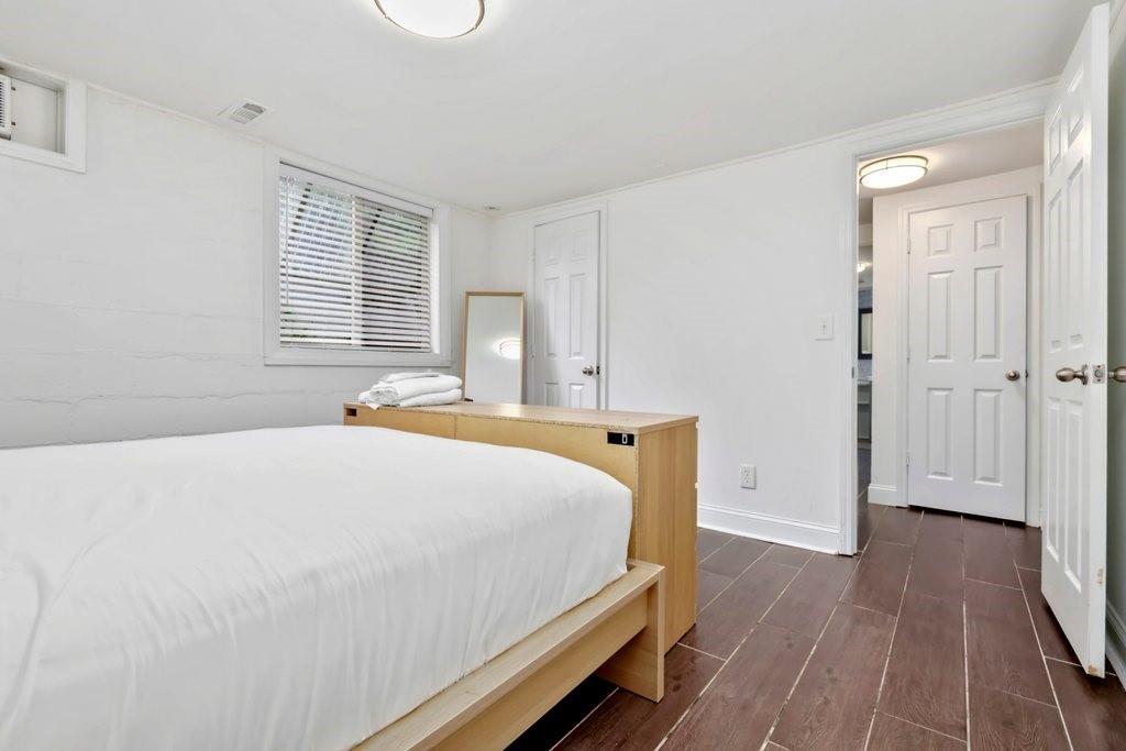 677 Holmes Street Northwest Atlanta, GA 30318 - Photo 22 of 31 a bedroom with a bed and wooden floor