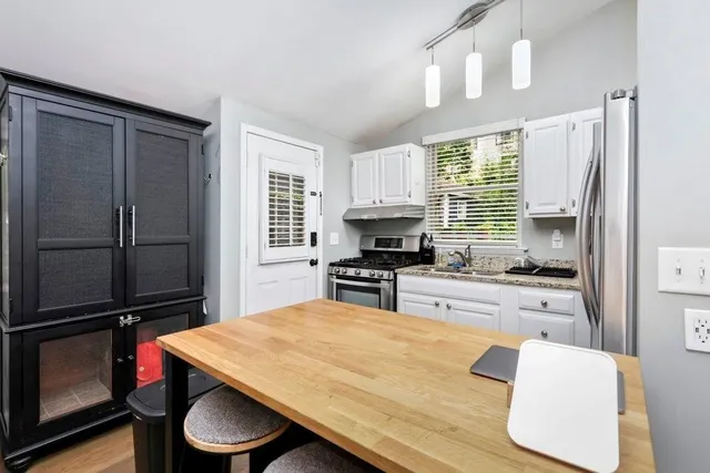 a kitchen with a refrigerator and a stove top oven