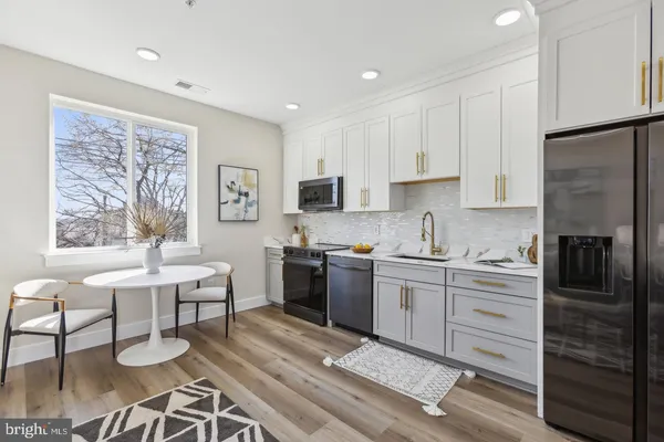 a kitchen with a refrigerator and a stove top oven