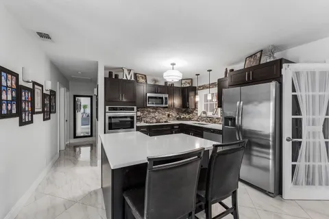 a kitchen with stainless steel appliances a refrigerator and a stove top oven