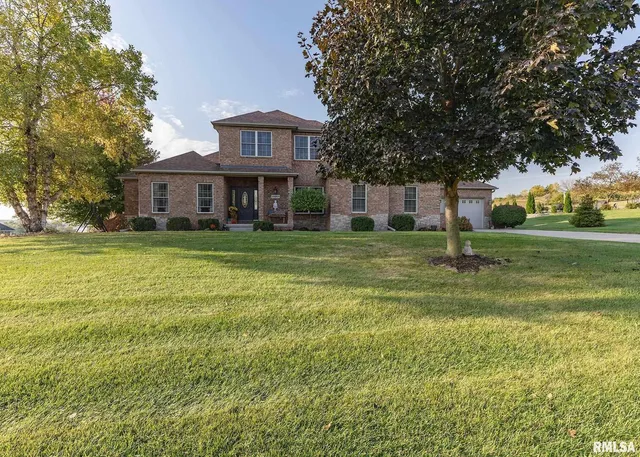 a view of a house next to a big yard with large trees