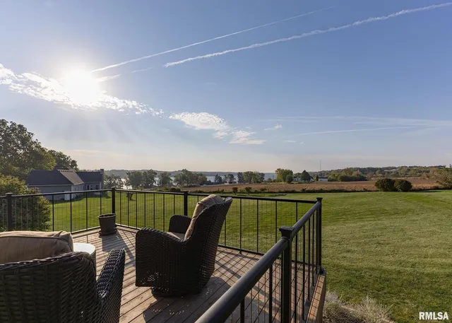 a view of a deck with couches plants and large trees