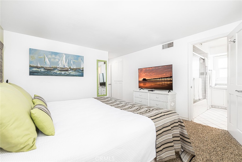 1720 West Oceanfront, Unit B Newport Beach, CA 92663 - Photo 15 of 28 a bedroom with a bed and a flat screen tv