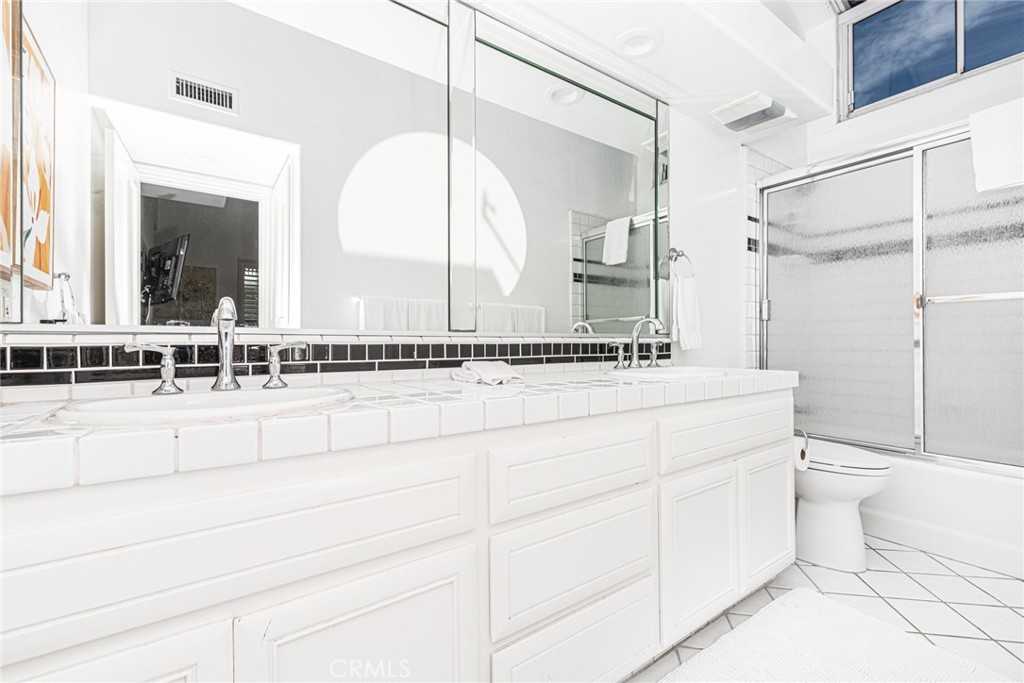 1720 West Oceanfront, Unit B Newport Beach, CA 92663 - Photo 16 of 28 a bathroom with a double vanity sink toilet and a mirror