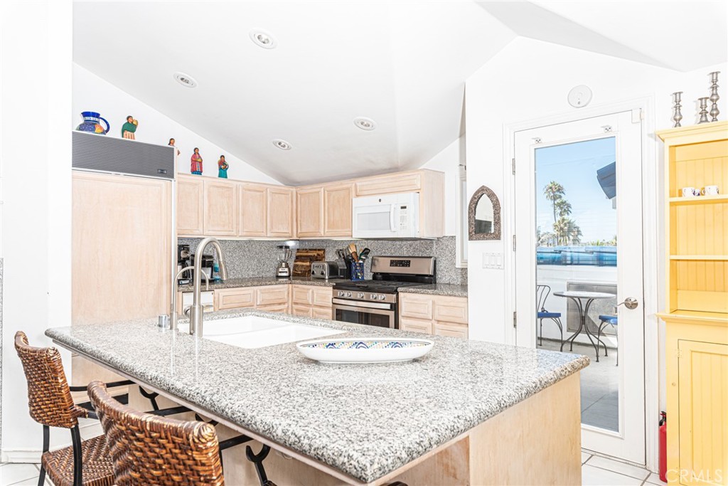 1720 West Oceanfront, Unit B Newport Beach, CA 92663 - Photo 3 of 28 a kitchen with granite countertop a sink and white cabinets