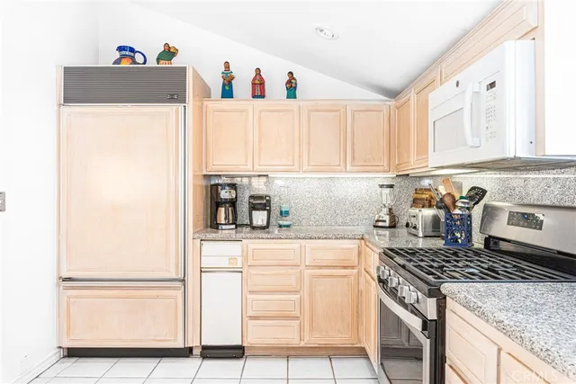 a kitchen with a stove and white cabinets