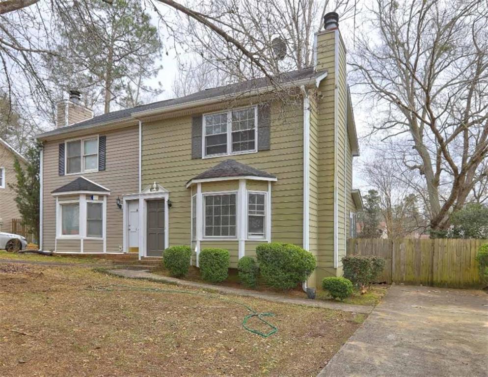 a front view of a house with a yard and trees