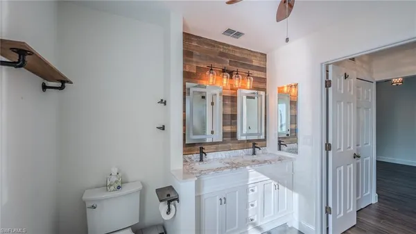a bathroom with a granite countertop sink a mirror and shower