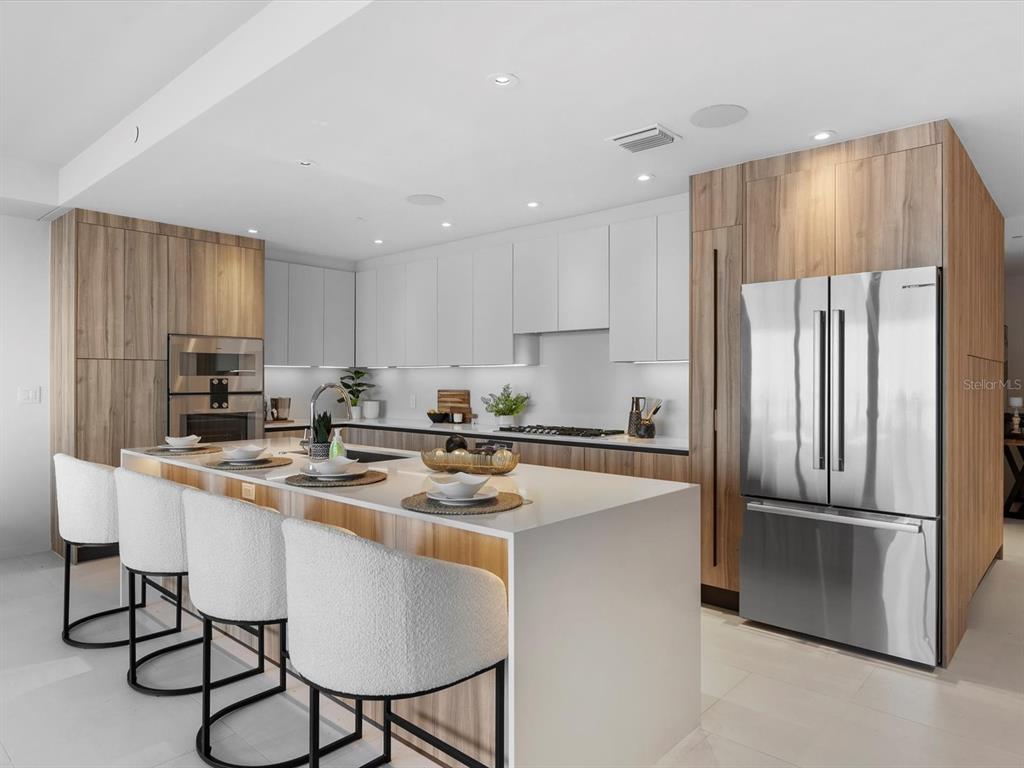 1020 Sunset Point Road, Unit 605 Clearwater, FL 33755 - Photo 8 of 35 a kitchen with stainless steel appliances granite countertop a refrigerator a stove a sink and a refrigerator