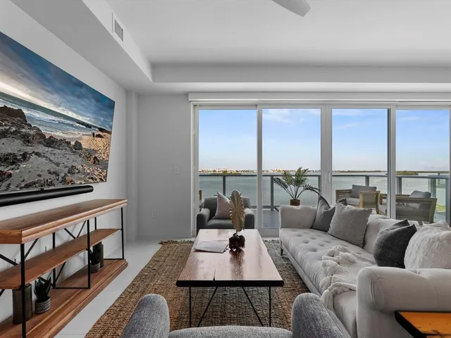 a living room with furniture potted plant and a large window