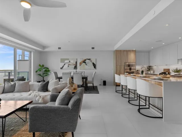 a living room with furniture ceiling fan and a large window