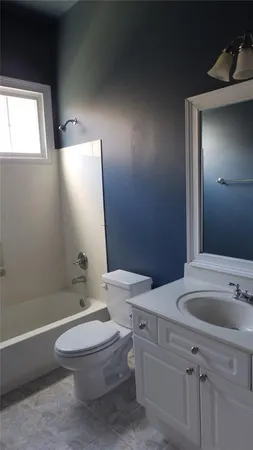 a bathroom with a toilet a sink a mirror and a bathtub