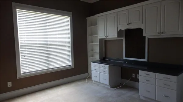a kitchen with stainless steel appliances granite countertop white cabinets and window