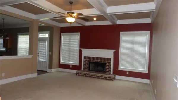 an empty room with fireplace and fan