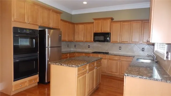 a kitchen with stainless steel appliances granite countertop a refrigerator sink and stove