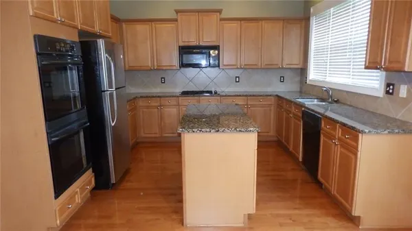 a kitchen with a refrigerator sink and cabinets
