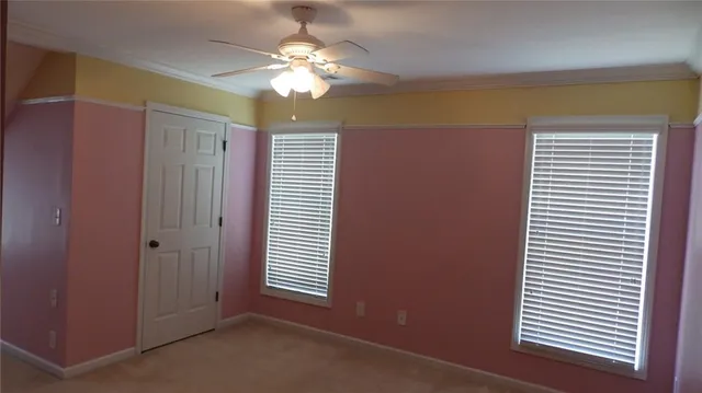 an empty room with windows and fan