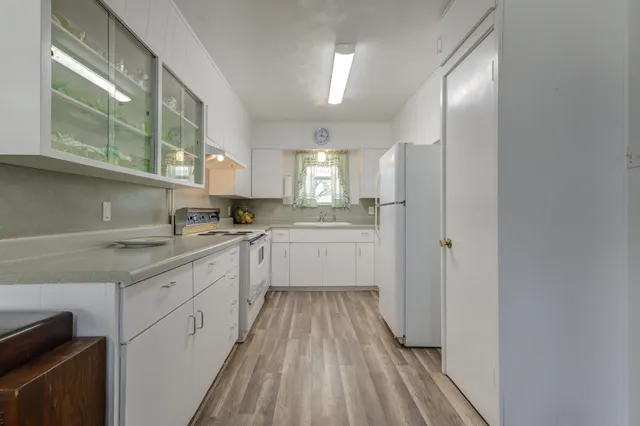 a kitchen with a sink a counter top space stainless steel appliances and cabinets