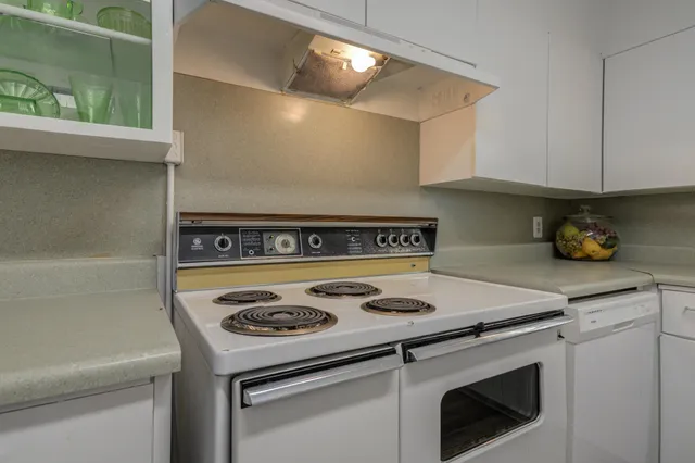a white stove top oven sitting inside of a kitchen