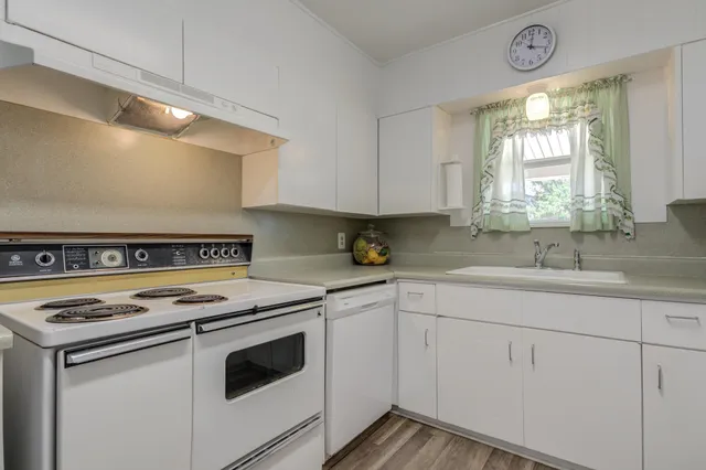 a kitchen with cabinets appliances a sink and a window