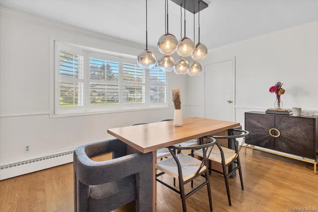 a view of a dining room with furniture a chandelier and wooden floor