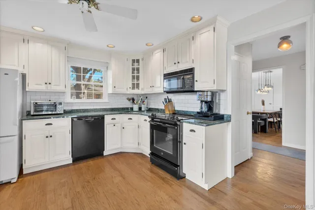 a kitchen with granite countertop white cabinets and white appliances