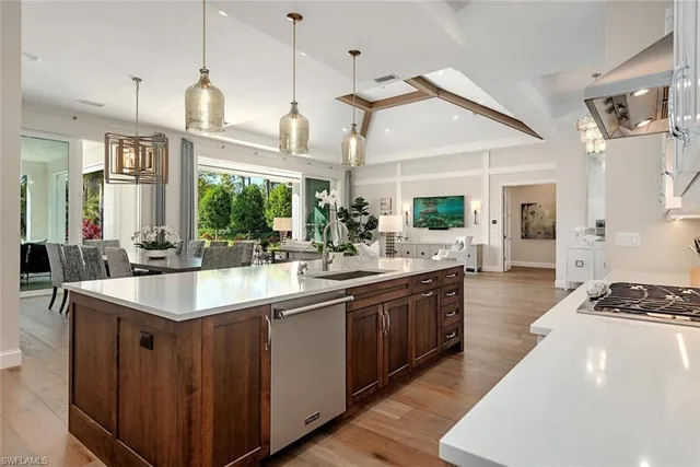 a kitchen with stainless steel appliances granite countertop a sink a stove and a wooden floors
