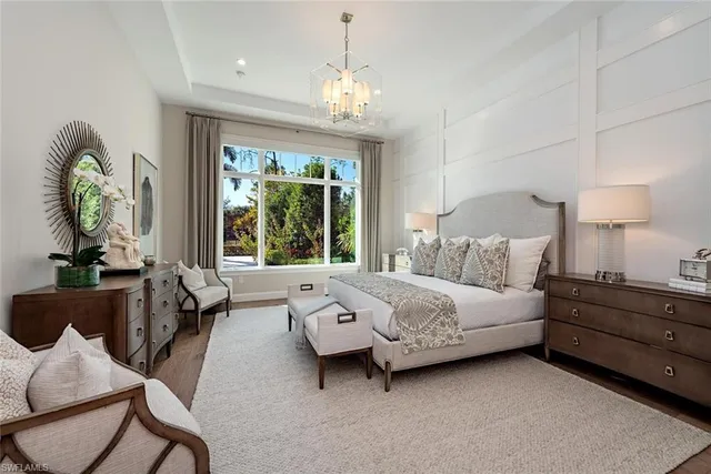 a spacious bedroom with a bed and a chandelier