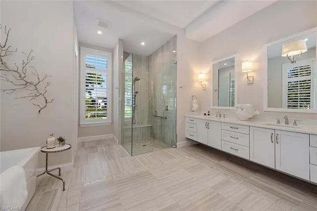 a large bathroom with a double vanity sink a toilet a large mirror and shower
