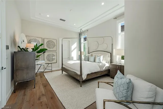 a bedroom with a bed and a potted plant on dresser