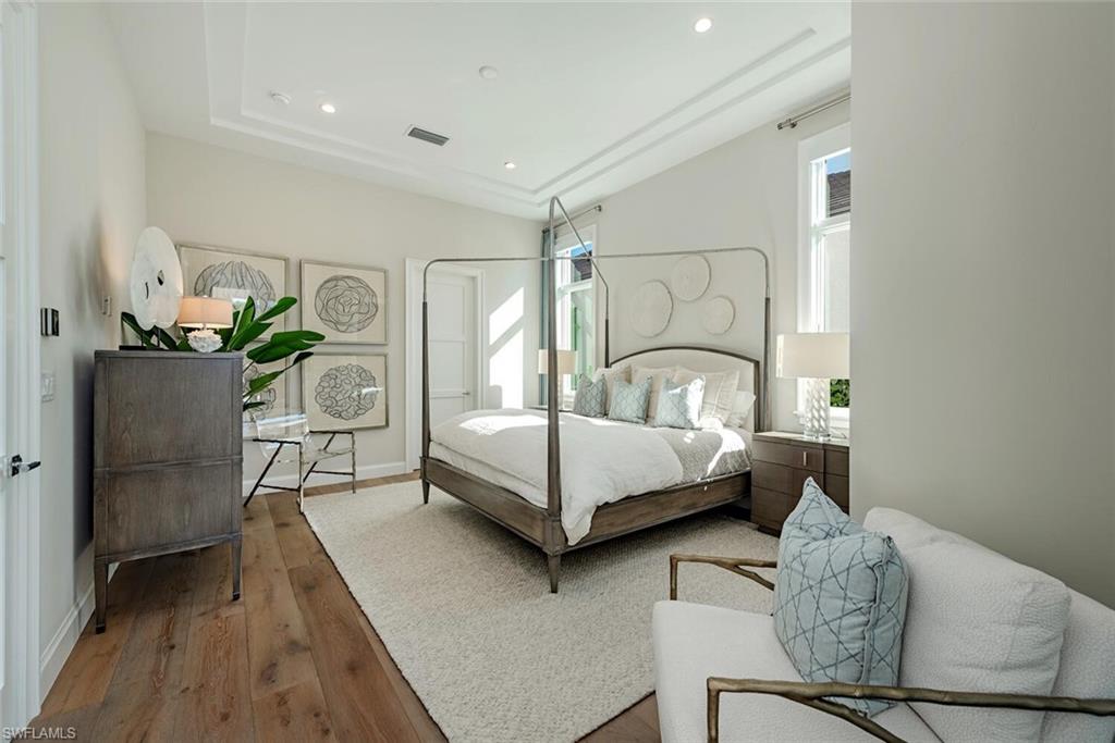 16715 Enclave Circle Naples, FL 34110 - Photo 21 of 33 a bedroom with a bed and a potted plant on dresser