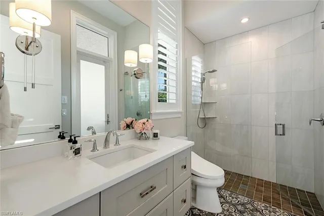 a bathroom with a sink a toilet and shower