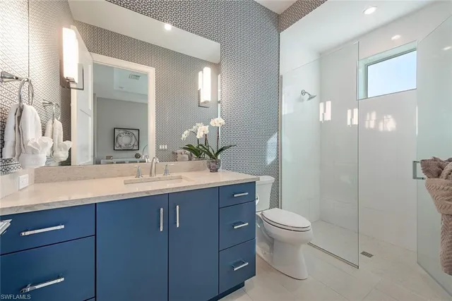 a bathroom with a granite countertop sink a toilet and a mirror
