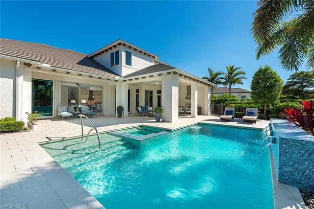 a view of a house with swimming pool and sitting area