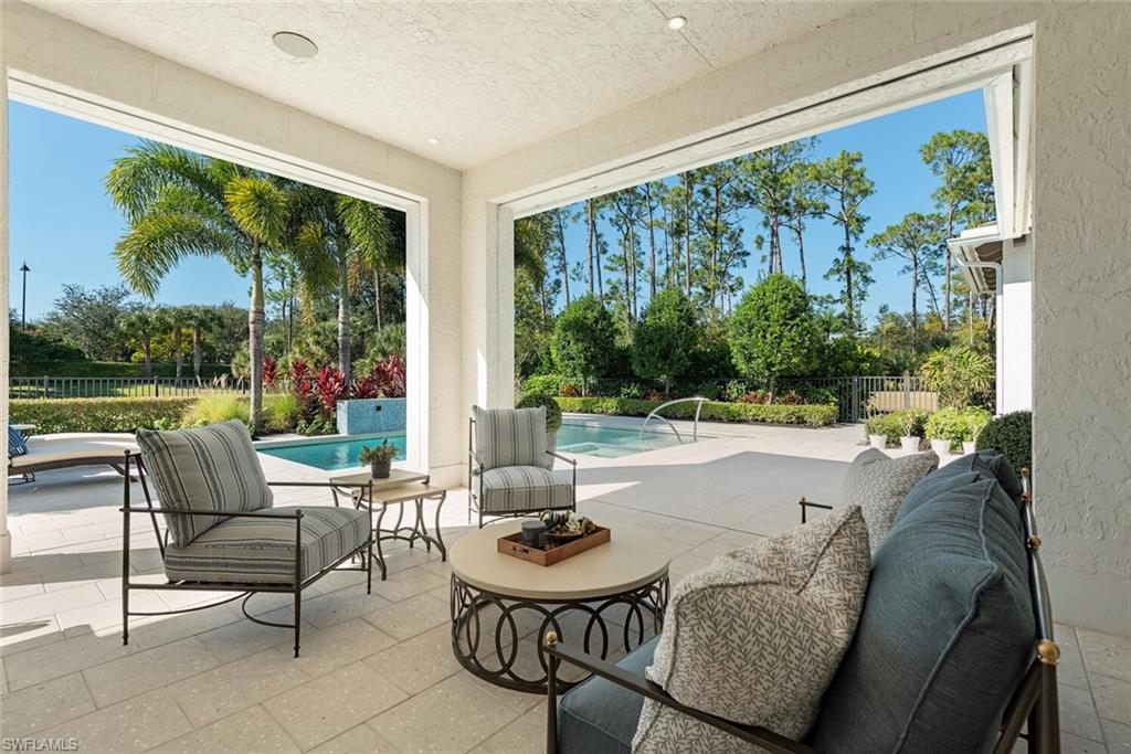 16715 Enclave Circle Naples, FL 34110 - Photo 8 of 33 a living room with patio furniture and a garden