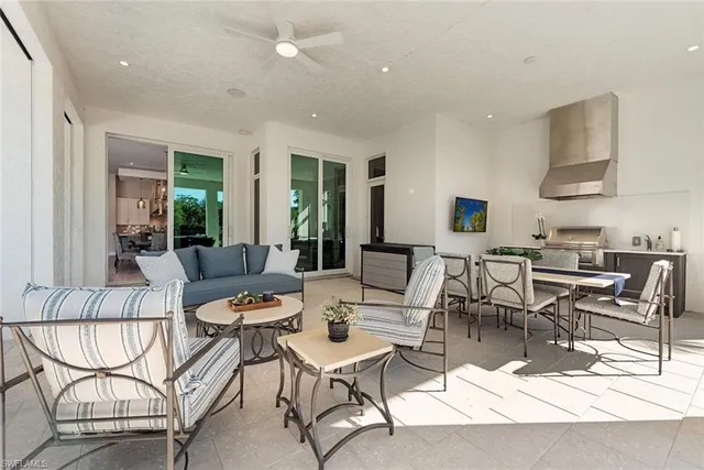 a living room with lots of furniture and a dining table with kitchen view